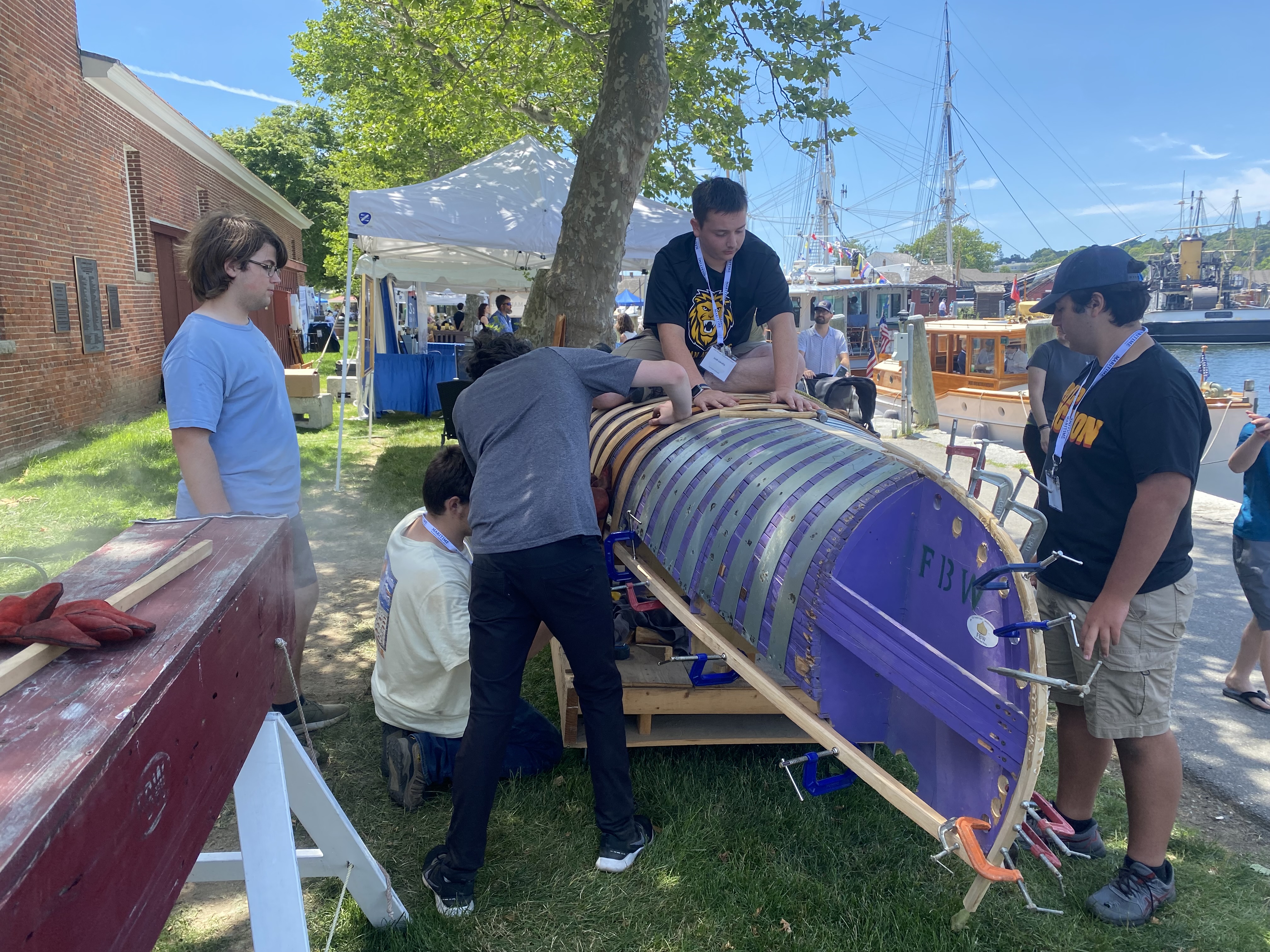 Students work on wooden boat